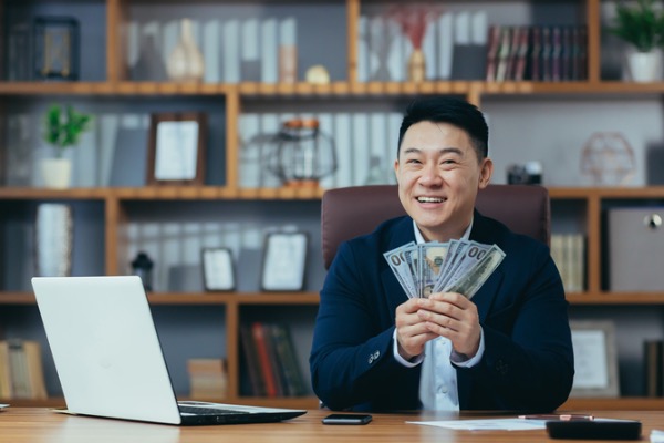 Man with money sitting at table. 